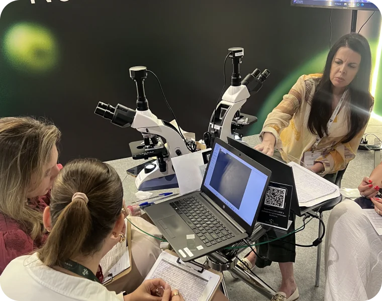 Participantes usando microscópios no estande da Nova Ciência